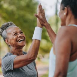 Two women high-fiving after a workout.