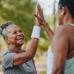 Two women high-fiving after a workout.