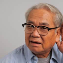 Man holds hand behind his ear