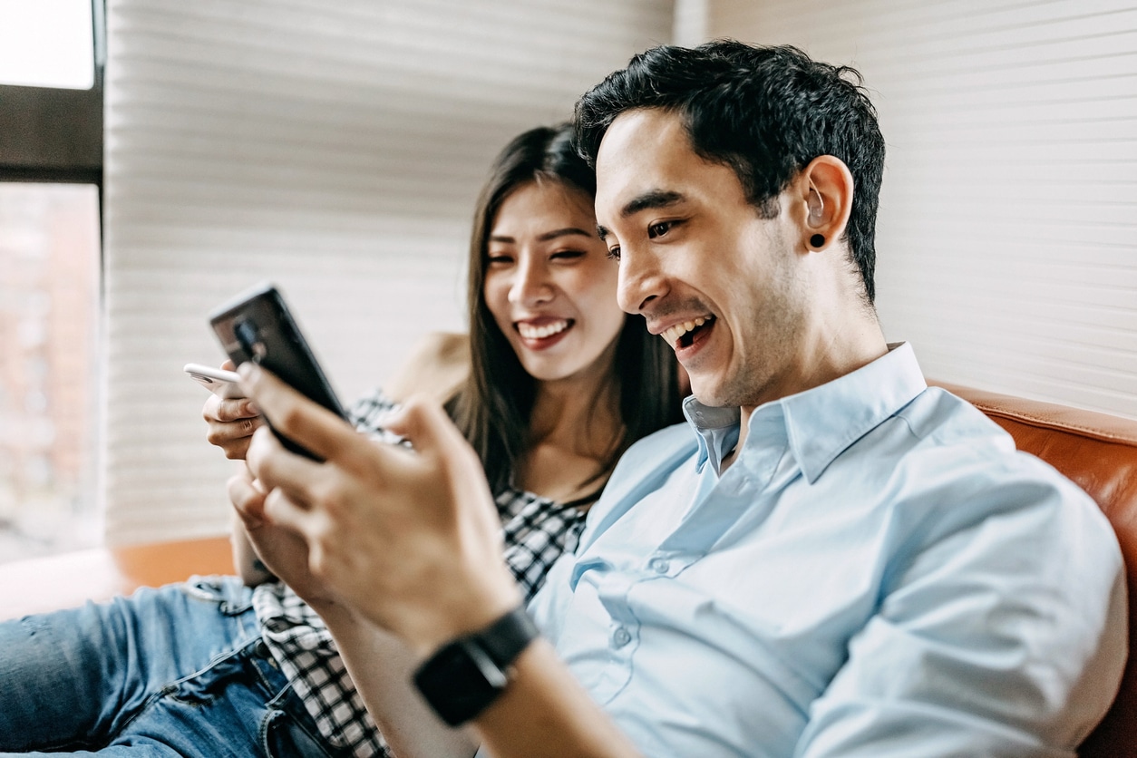 Man wearing a hearing aid and looking at his home with his girlfriend.