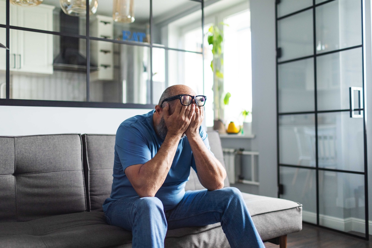 Stressed man sitting with his head in his hands