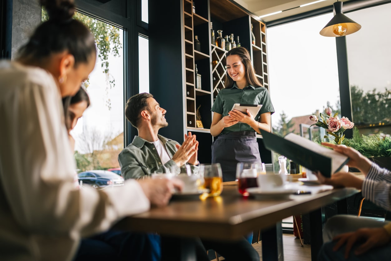 Group of people ordering food from the server. 