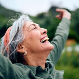 Senior woman smily with her hands up