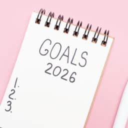 Notebook with "goals 2026" and a bulleted list.